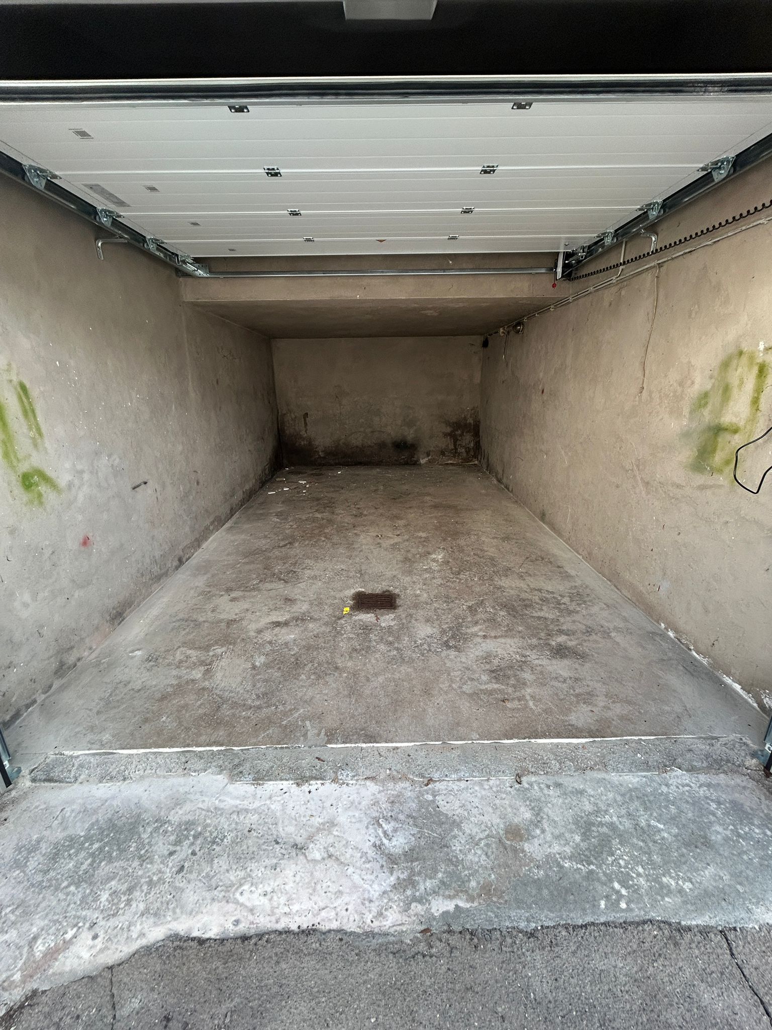 Garagenboden vorher: rissiger, verschmutzter Beton mit Verfärbungen
